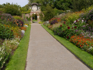 Doppel-Mixed-Border, Nymans Garden, mit Mauer-Tor