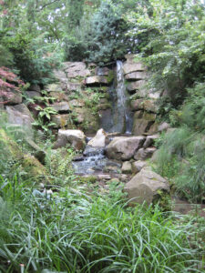 Wasserfall auf Weg zur Flussaue in Abbey House Gardens