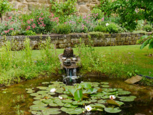 Der Gartenteich, dahinter das Mauerbeet im Garten Schlegelmilch